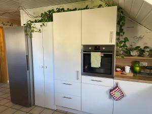 cocina con armarios blancos y horno en Ferienwohnung-Entspannung Pur, en Krombach