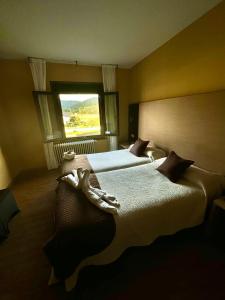 a hotel room with two beds and a window at apartamento Laza in Laza