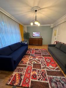 a living room with a blue couch and a rug at TAKSİM PERA House in Istanbul