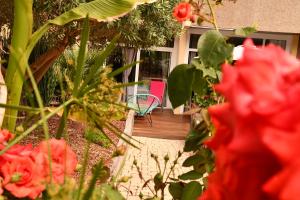Elle offre une vue sur une terrasse avec des fleurs rouges et une chaise. dans l'établissement kerloch gwen, à Combrit
