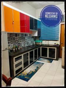 uma cozinha com armários coloridos e tapetes no chão em Homestay Tmn Pelangi Jaya 1 kluang free wifi em Keluang