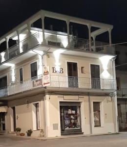 duży biały budynek z balkonem na górze w obiekcie Le Antiche Colonne w mieście Cinquefrondi