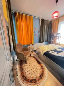 1 dormitorio con 1 cama, 1 silla y 1 alfombra en TAKSİM PERA House, en Estambul