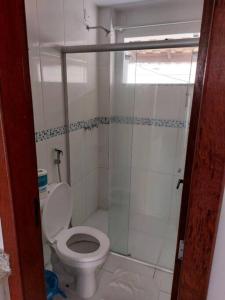 Un baño con inodoro y ducha de cristal. en Casa 22B, MONT HEBROM, en Porto Seguro