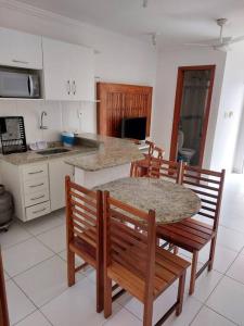cocina con mesa, sillas y barra en Casa 22B, MONT HEBROM, en Porto Seguro