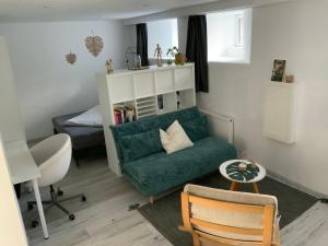 uma sala de estar com um sofá verde e uma cama em Casa Viva - Separate, ruhig gelegene Wohnung em Quierschied