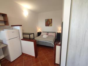 a small room with a bed and a refrigerator at B&B Villa Nicoletta in Peschici