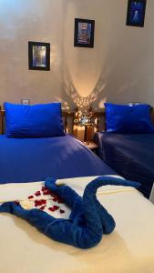 eine blaue Decke auf einem Bett in einem Schlafzimmer in der Unterkunft RIAD SULTAN Marrakech in Marrakesch