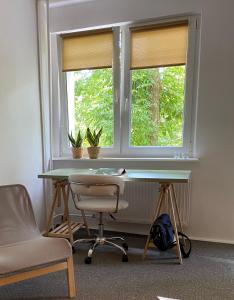 ein Büro mit einem Schreibtisch, einem Fenster und einem Stuhl in der Unterkunft Broniewskiego Centrum Konin in Konin