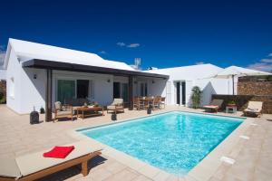 a swimming pool on a patio with a house at Villa Coral in Puerto del Carmen