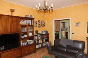 a living room with a leather chair and a television at In Famiglia in Biella