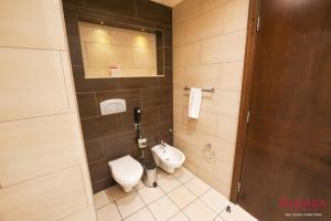 La salle de bains est pourvue de toilettes et d'un lavabo. dans l'établissement Ramada Downtown Abu Dhabi, à Abu Dhabi