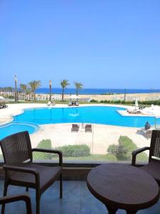 a patio with two chairs and a table and a pool at The Groove Ain Sokhna in Ain Sokhna