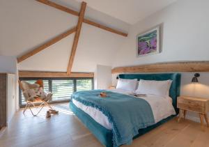 a bedroom with a large bed and a chair at Alexandra Barn in Shadingfield