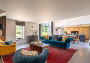 ein Wohnzimmer mit blauen Sofas und einem Tisch in der Unterkunft Alexandra Barn in Shadingfield