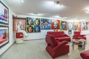 una sala de estar con sillas rojas y carteles en la pared en Hotel Muza, en Košice