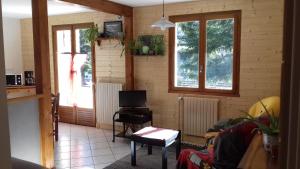 a living room with a tv and two windows at Villa Soleil 12 rue Joseph Mathieu in Guillestre