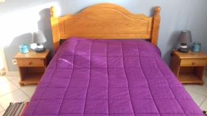 a bed with a purple comforter in a bedroom at Villa Soleil 12 rue Joseph Mathieu in Guillestre