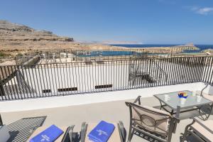 a balcony with chairs and a table with a view at Villa Nouna in Líndos