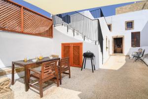 a patio with a table and chairs and a staircase at Villa Nouna in Líndos