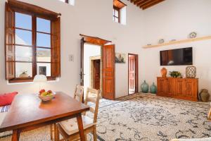 a living room with a table and chairs and a television at Villa Nouna in Líndos