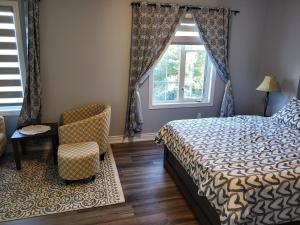 a bedroom with a bed and a chair and a window at Luxury Home in Mississauga in Mississauga