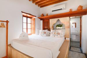 a bedroom with a large white bed with a window at Villa Nouna in Líndos