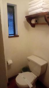baño con aseo blanco y ventana en Club de Vela Santa María en Valle de Bravo