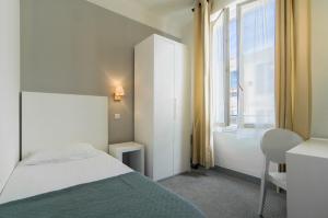 a bedroom with a bed and a large window at Hôtel P.L.M. in Cannes
