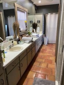 a bathroom with a sink and a large mirror at Around the Bend Bungalow in Fredericksburg