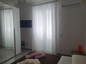 een slaapkamer met een bed en een groot raam bij Casetta Bella Nonna Rosetta in Mondello