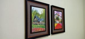 two framed pictures of a house on a wall at Recanto das Neves in Miguel Pereira