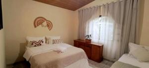 a bedroom with two beds and a window at Recanto das Neves in Miguel Pereira