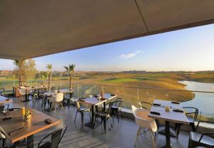 un restaurante con mesas y sillas y una gran ventana en Condo à Prestigia Agate - Golf city Marrakech, en Marrakech