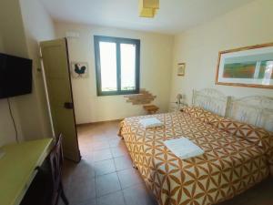 1 dormitorio con 1 cama y TV en Don Federico Country Inn, en Moscufo