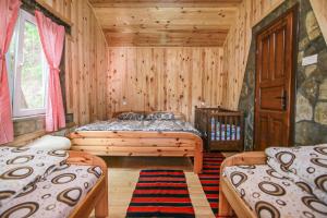 - une chambre avec 2 lits dans une cabane en rondins dans l'établissement Country Villa MMMM, à Mojkovac