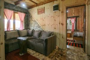 a living room with a leather couch and wooden walls at Country Villa MMMM in Mojkovac