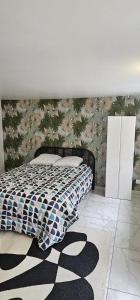 a bedroom with a bed with a floral wall at calme appartement de vacances in Écouen