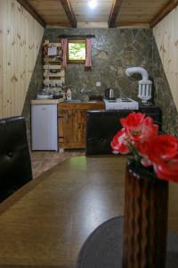 una cucina con tavolo in legno e vaso di fiori di Country Villa MMMM a Mojkovac