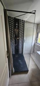 a bathroom with a shower with a glass wall at calme appartement de vacances in Écouen +5 photos