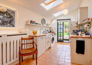 a kitchen with a table and a chair in it at Celebration Cottage - Southwold in Southwold