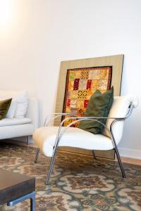 una sedia bianca con cuscino verde in soggiorno di Luxury stay experience in Bari a Bari
