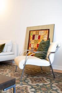 a white chair with a green pillow in a living room at Luxury stay experience in Bari in Bari