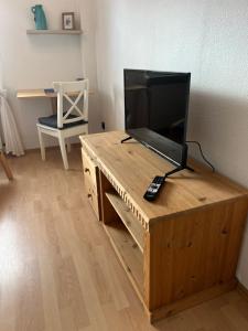 TV de pantalla plana en la parte superior de un escritorio de madera en Auszeit im Pott - Ferienwohnung Minze en Herten