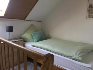 a bed in a small room with a staircase at Auszeit im Pott - Ferienwohnung Minze in Herten