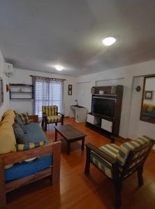 a living room with a bed and a flat screen tv at AMPLIO Y LUMINOSO in Concordia