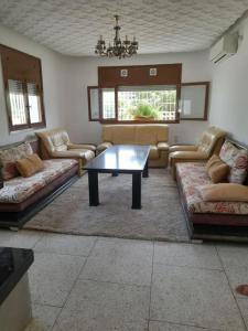 a living room with couches and a table at superbe appartement bien placé in Fès