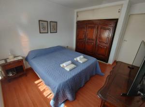 um quarto com uma cama azul com duas toalhas em AMPLIO Y LUMINOSO em Concordia