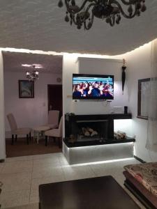 een woonkamer met een flatscreen-tv boven een open haard bij superbe appartement bien placé in Fès