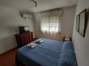 a bedroom with a blue bed with two towels on it at AMPLIO Y LUMINOSO in Concordia